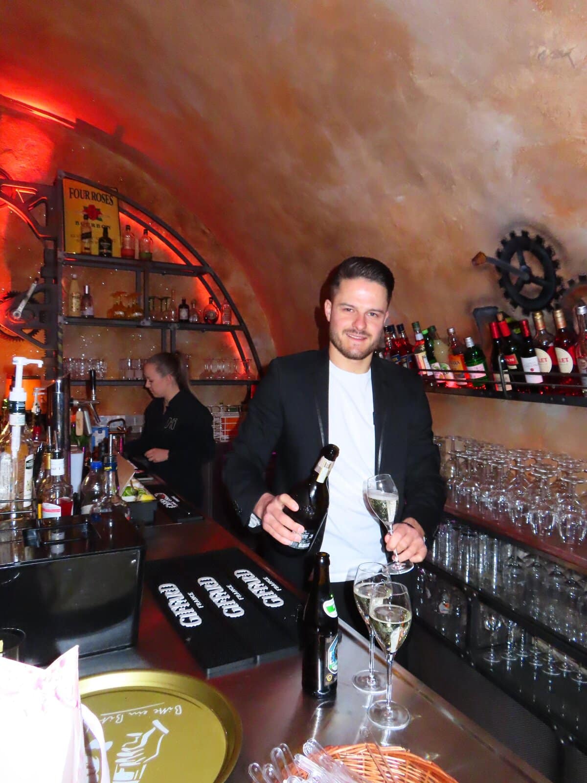 Barkeeper schenkt Champagner ein an der Bar im Gewölbekeller der D48 Bar Aschaffenburg