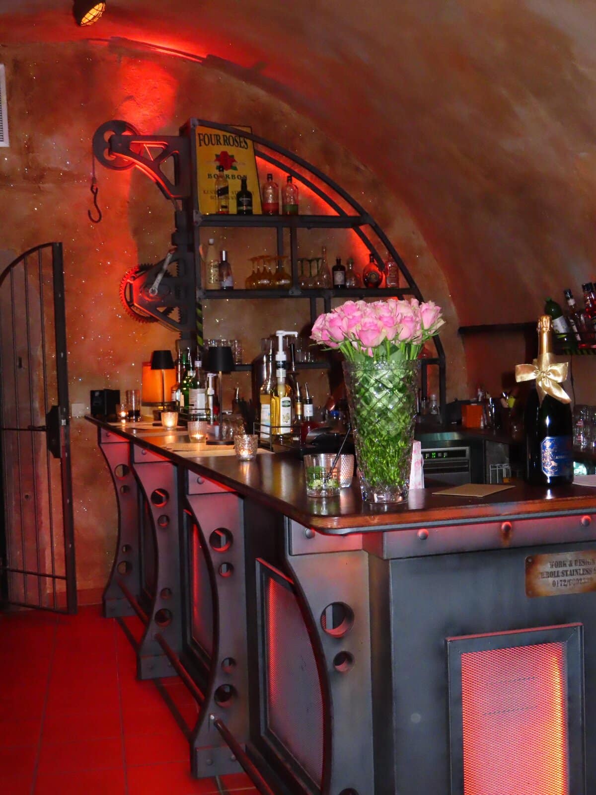 Stylischer Bar-Tresen im Industrial-Design mit frischen Rosen im Gewölbekeller der D48 Bar